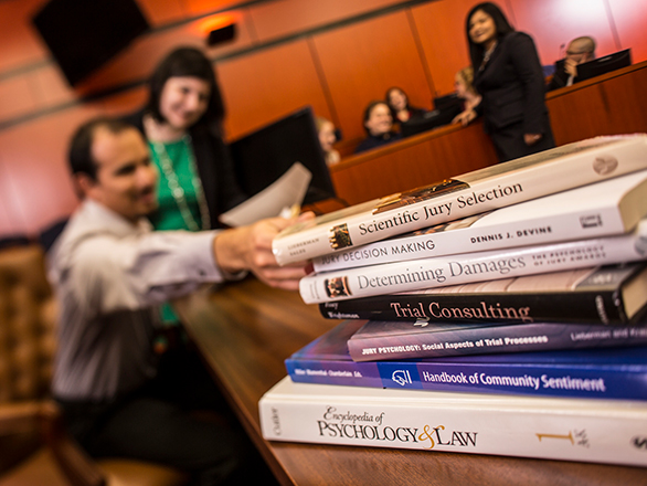 Students studying at table with stack of books