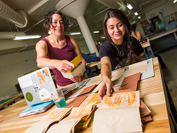 Student and professor show off book art in press lab