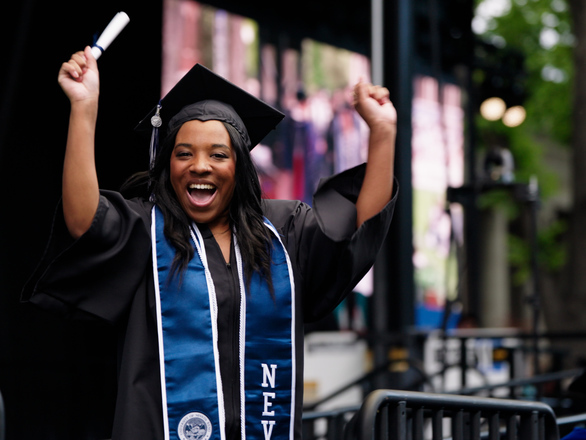 woman in graduation gown cheering