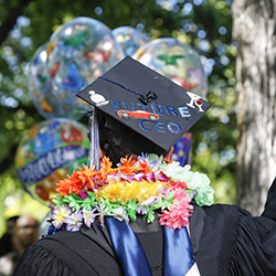 Student in graduation regalia wearing mortar board