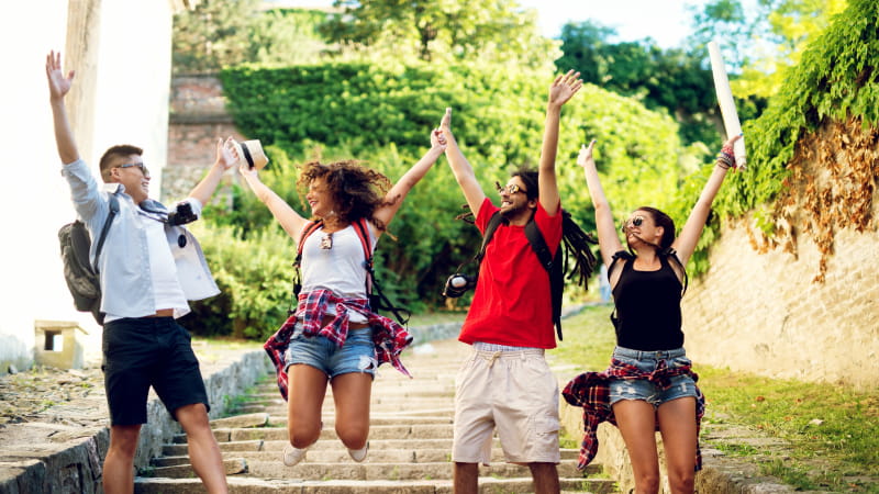 four students jumping with hand raised while studying abroad