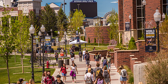 People walking on sidewalk in front of student union and Knowledge Center