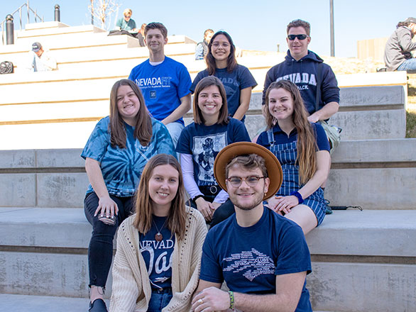 Student Advisory board members sit on cement steps outside the Pennington Achievement Center
