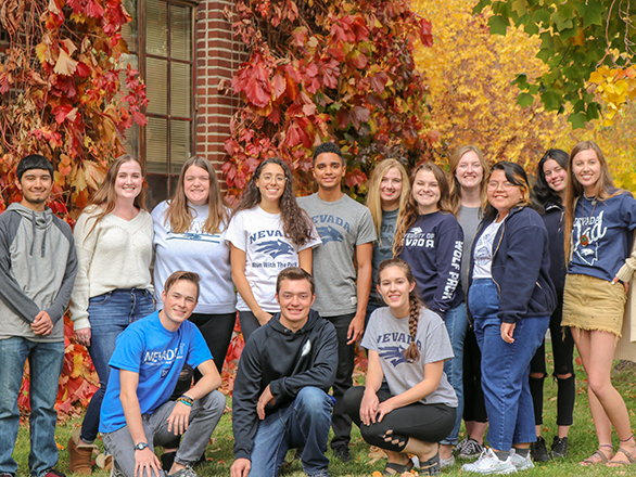 Student Advisory Board group stands in front of building with ivy