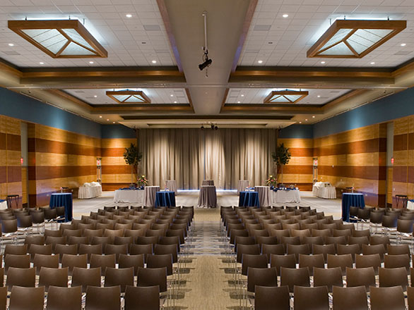An empty presentation room filled with chairs and a large stage.