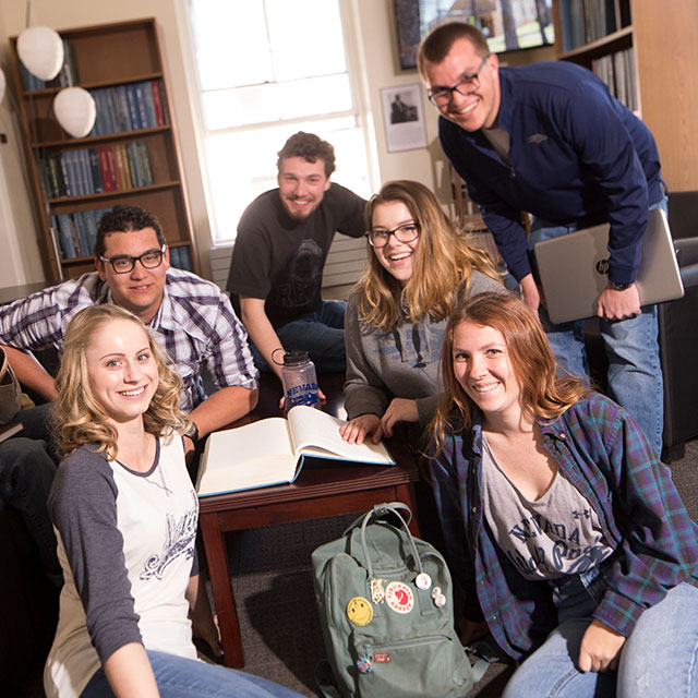Students sitting inside museum space smiling