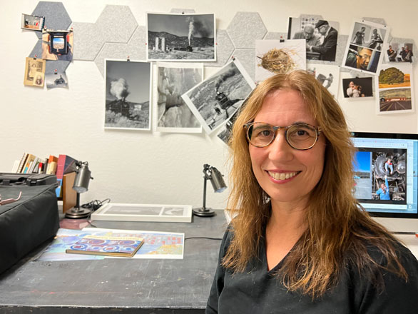 Anna Newman smiling, standing in front of her work station