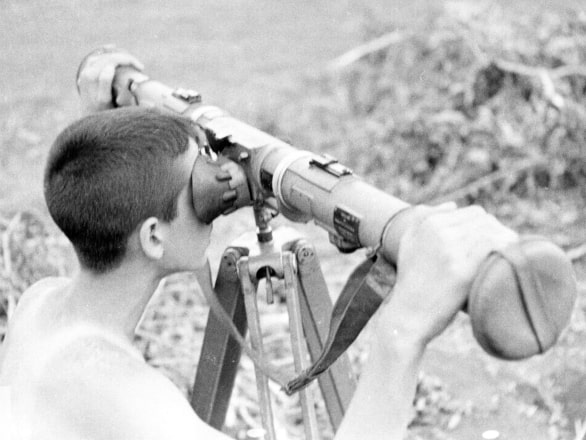 black and white photograph of boy looking through viewfinder 