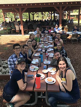 kids smiling at long table eating meal together