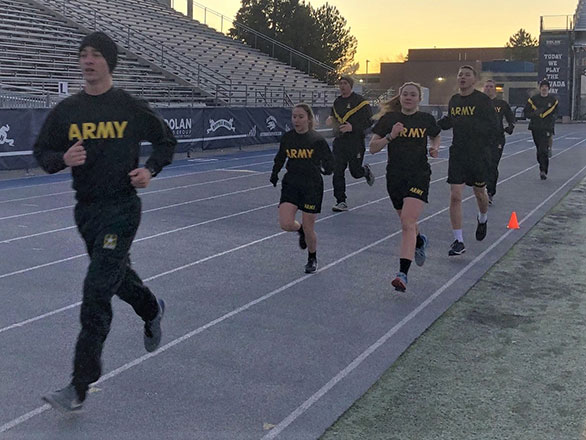 ROTC students run on the track in army training clothes