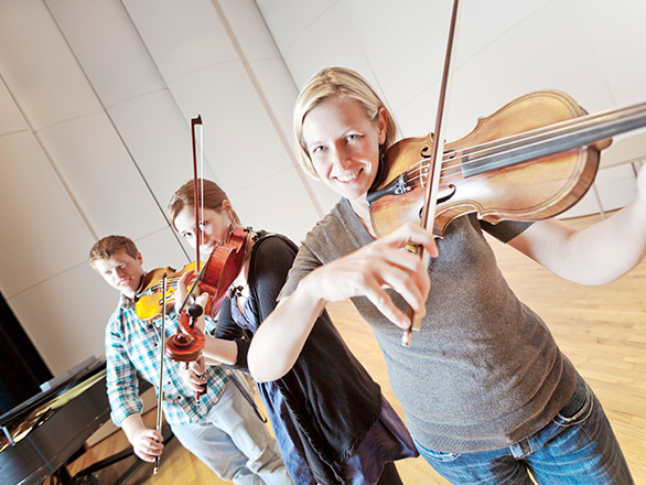 Three students playing violin
