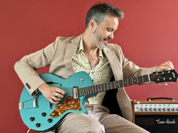 man tuning guitar