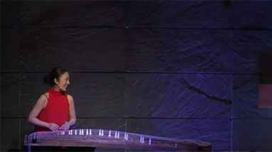 Yumi plays koto instrument on stage