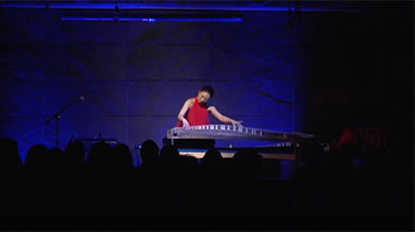 Yumi plays koto instrument on stage