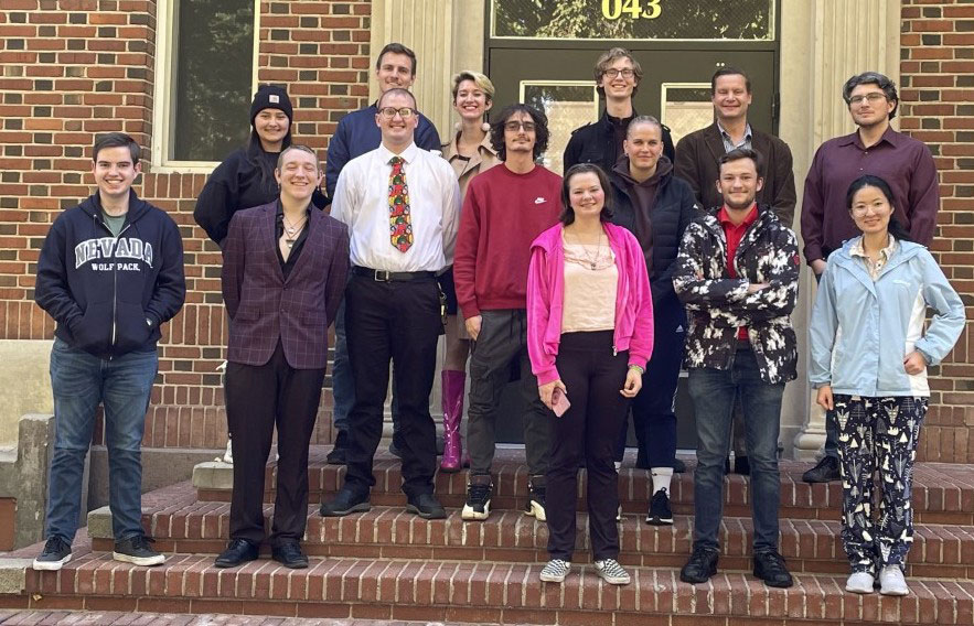 A group os students standing on the steps of a brick building