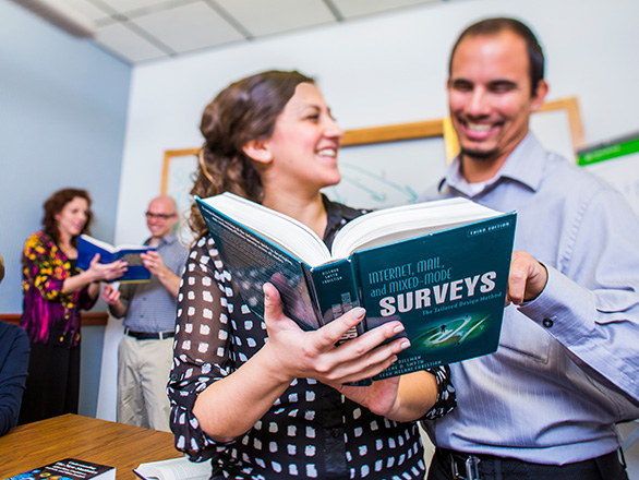 Two people look over research book
