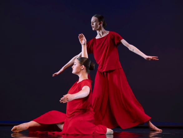 two women in red dresses dancing