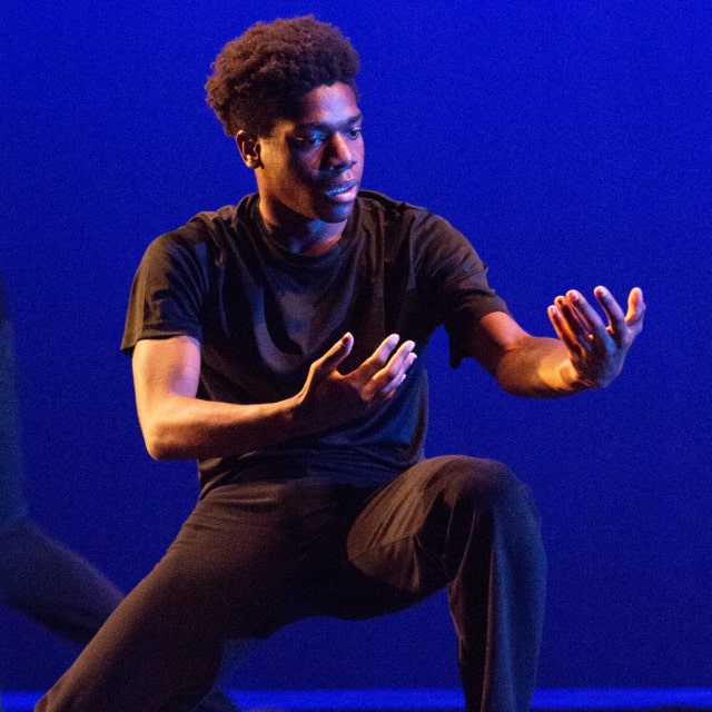 man looking at hands with blue background