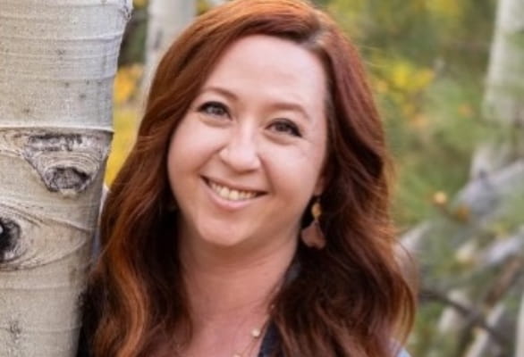 woman smiling next to tree