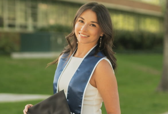 girl smiling with graduation stole and cap