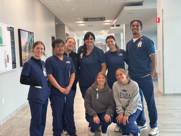 A group of Orvis School of Nursing students, four standing and two kneeling, pose for a group photo.