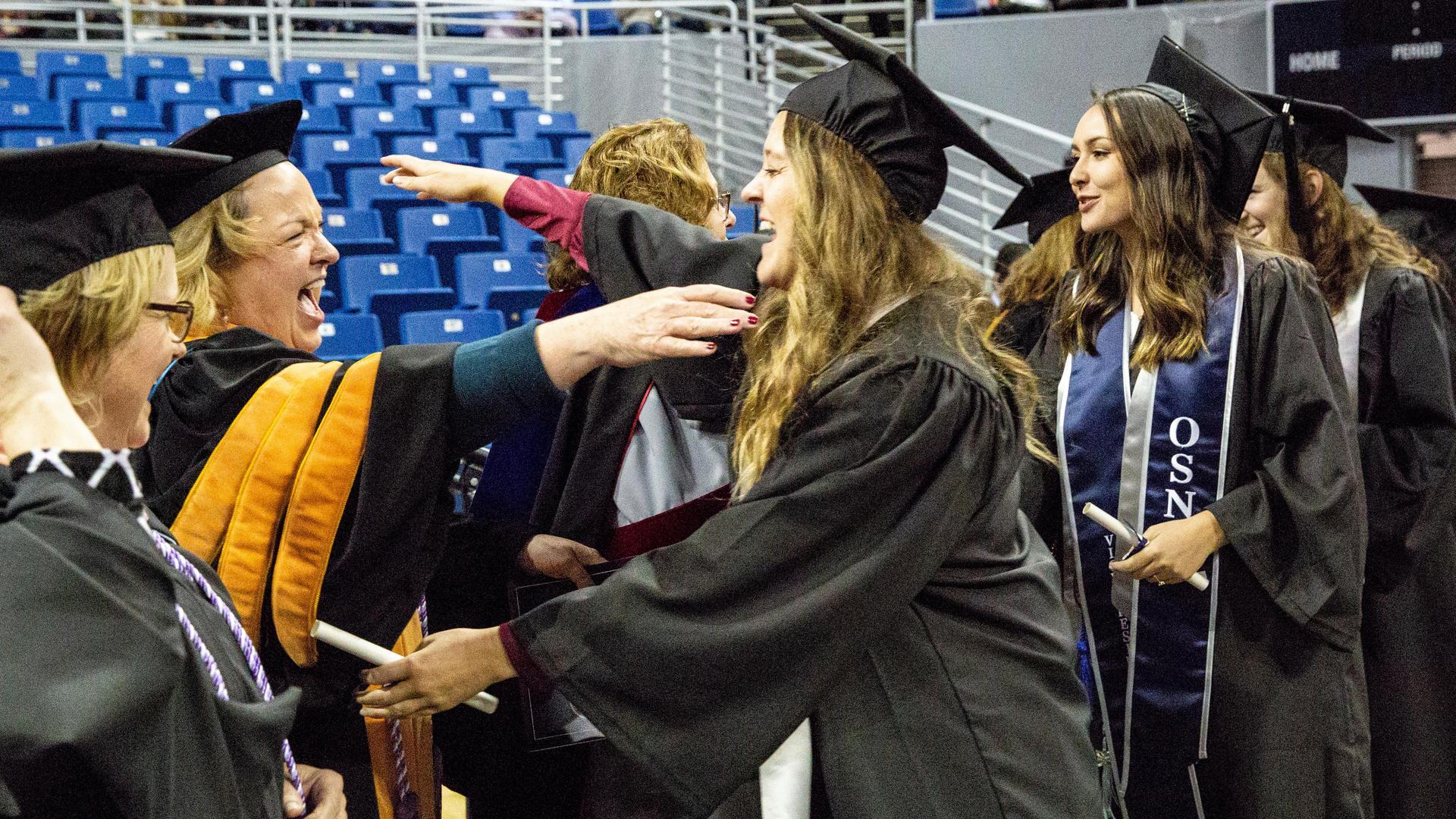 Four Orvis School of Nursing Students poses for a picture while wearing nursing scrubs and stethoscopes. 