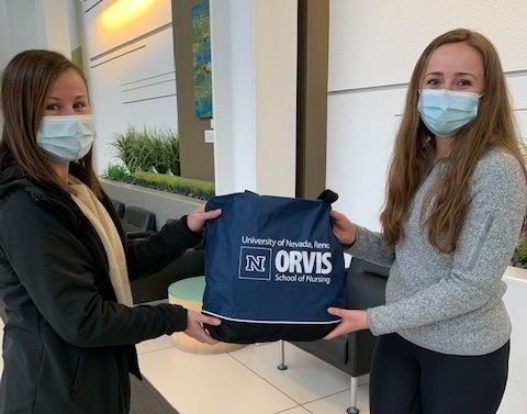 two nursing students holding a supplies bag in the nursing school