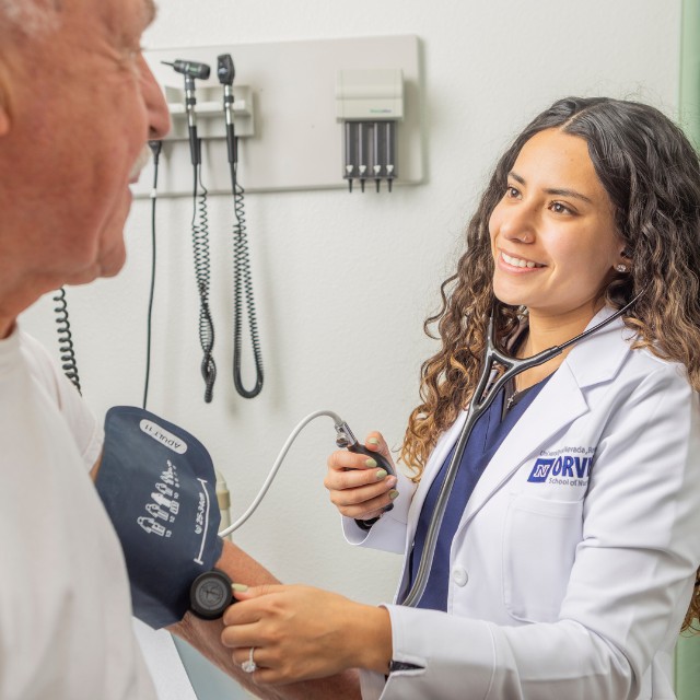 Nurse practitioner taking blood pressure of a patient.