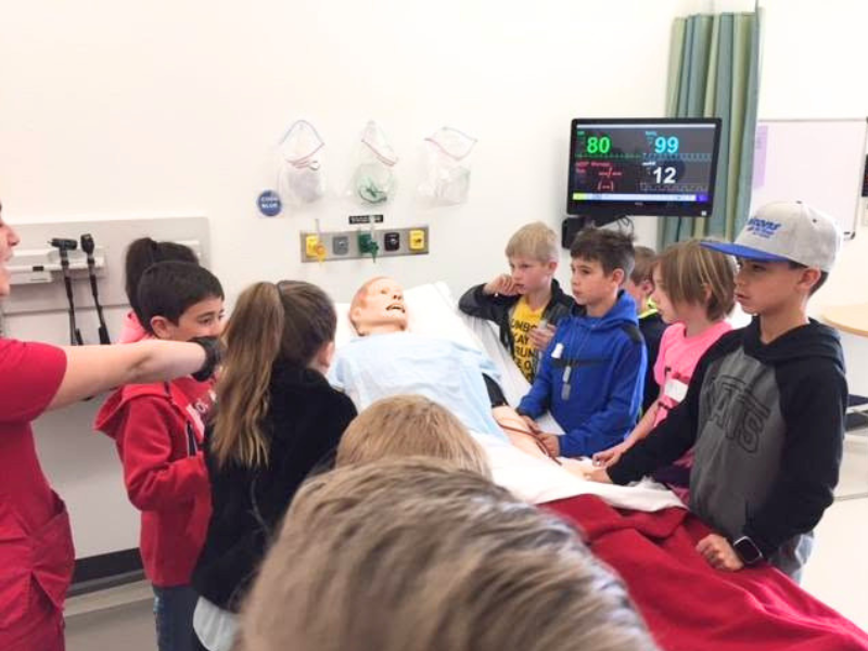 Children in a simulation room with a manikin
