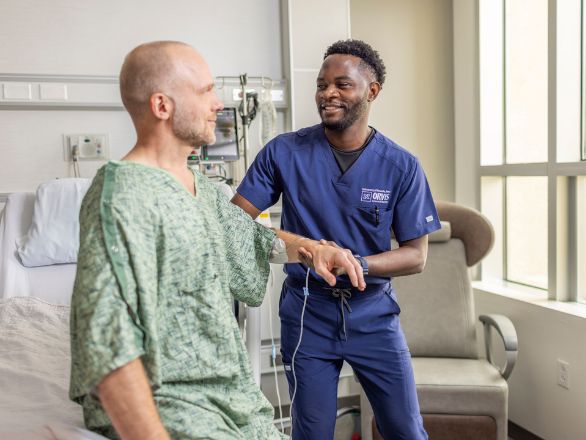 A nurse helps a patient get out of bed.