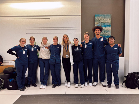 An OSN faculty members poses with nursing students for a group photo.
