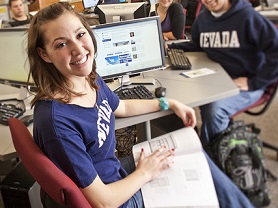 Student in front of laptop with notebook in lap
