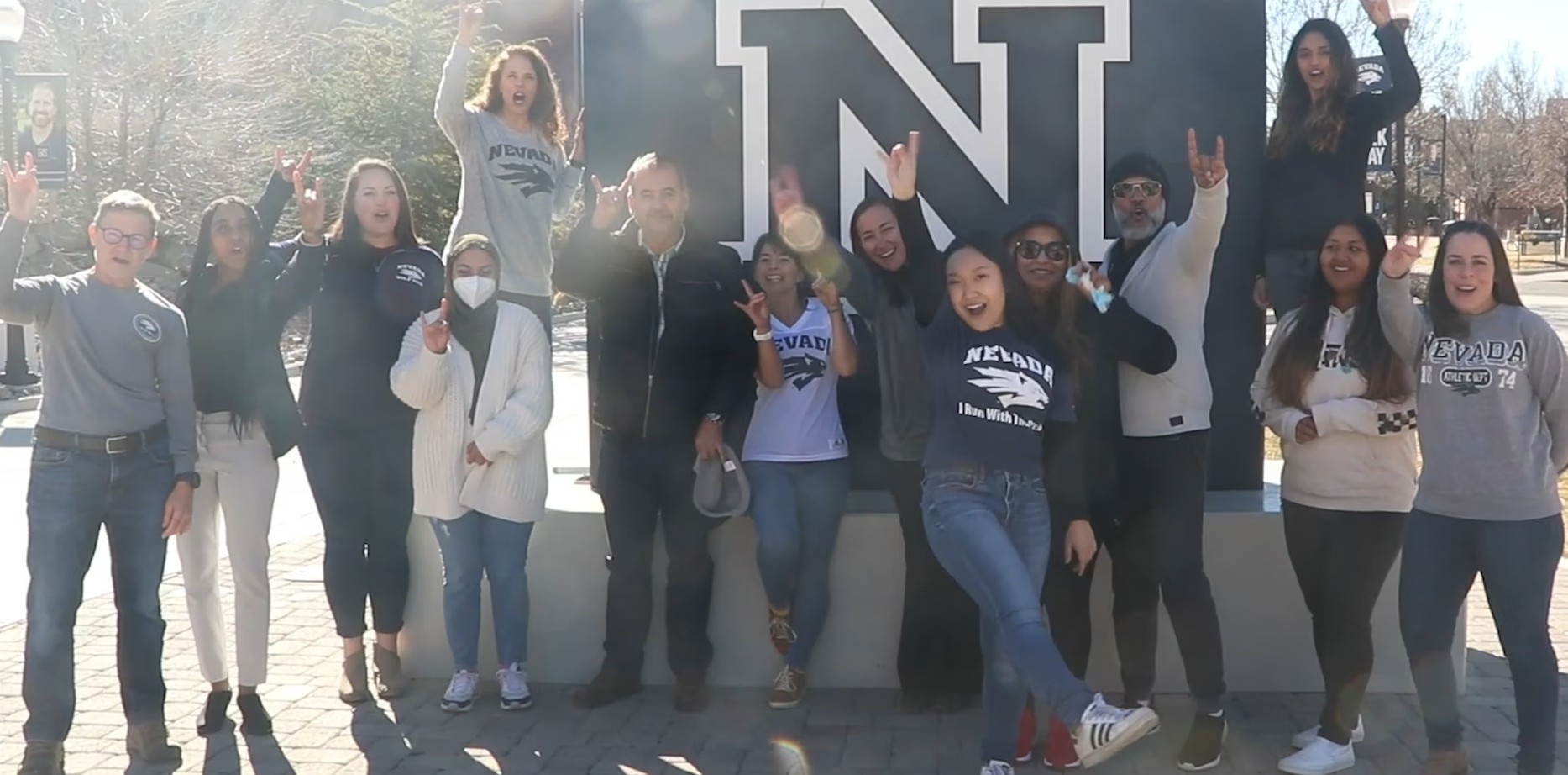 School of Public Health DEI Committee members smiling in front of the the block 'N' sign in front of the library