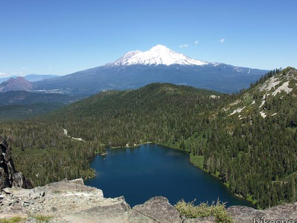Aerial shot of Castle Lake with snow covered Mount Shasta in the distance.