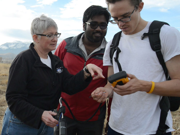 Wendy Calvin instructs two students on how to use a research instrument.