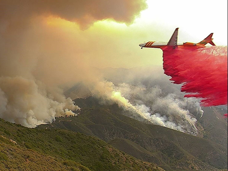 An airplane assists firefighting efforts during a wildfire