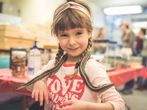 Young girl holding snake