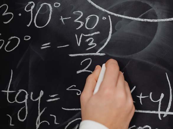 Hand drawing math equations on a chalkboard