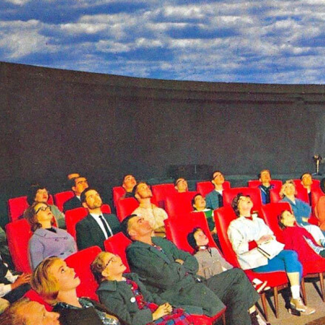Audience in the Full-Dome Theater in 1963 watching the blue sky and clouds projected on the ceiling at the Fleischmann Planetarium.