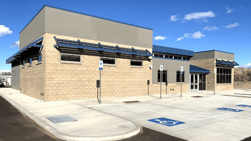 Image of Main Station Farm Science Center building with accessible parking and desert landscape in the background.