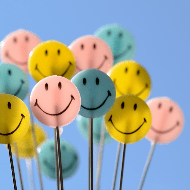 stock image of happy faces on sticks