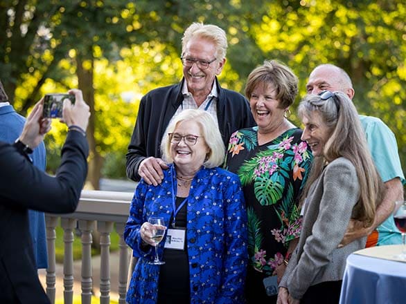 A group of five alumni reunion attendees pose for a picture.