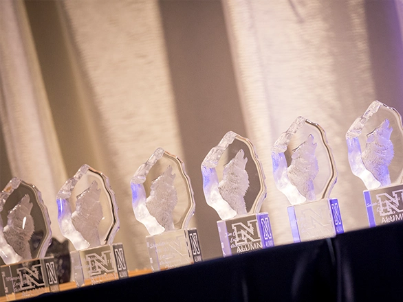 Six different crystal Nevada Alumni Association awards sit on a table.
