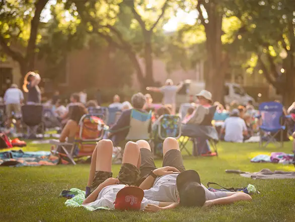 People lay on the grass and sit in groups on the Quad at the University of Nevada, Reno during a Pack Picnic event.