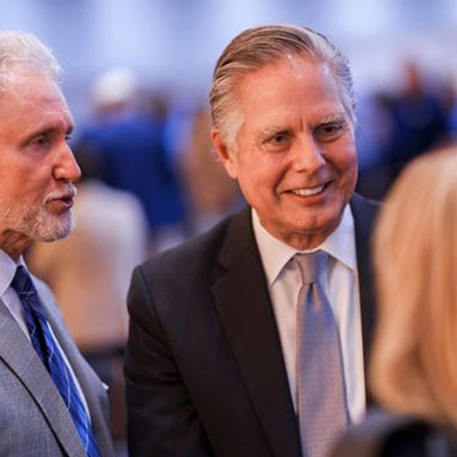 Dean Greg Mosier talks to two individuals during the John Tulloch Business Building opening ceremony.