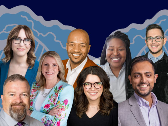 A group of seven people pose in front of a stylized mountain-themed backdrop. The front row includes three individuals, and the back row has four. All are smiling and dressed in a mix of business and casual attire, including blazers, shirts, and glasses.