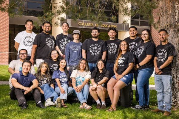 A group of people dressed in similar shirts poses together, all smiling for the camera.