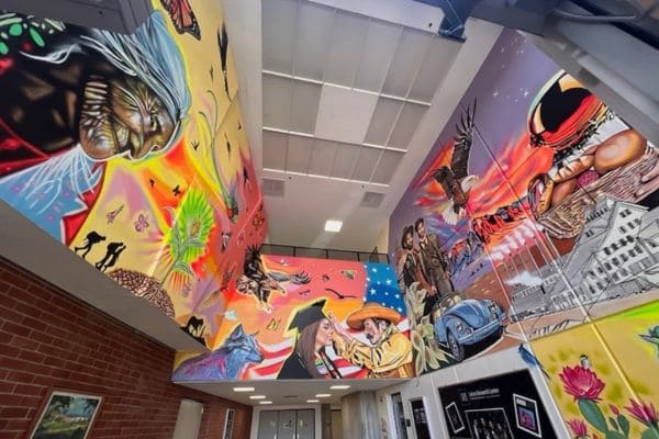 A colorful mural featuring a prominent image of a man and woman, showcasing artistic expression on a wall.