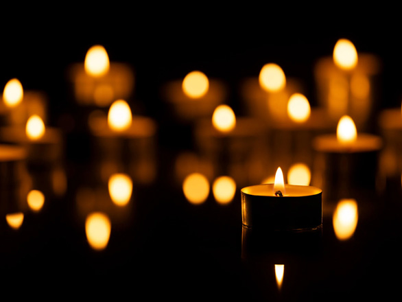 Tea lights flicker in a dark room.