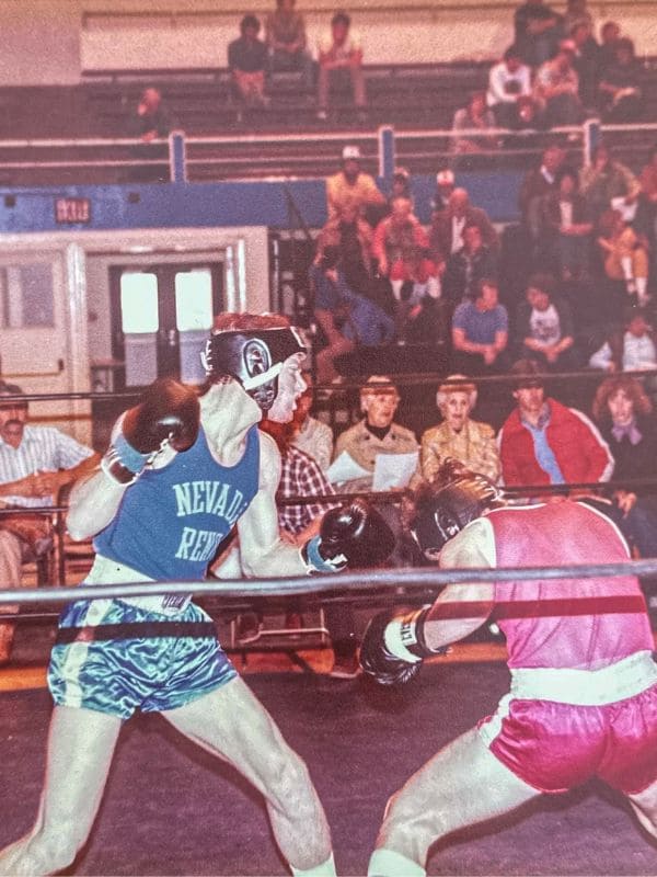 Two men wearing different colored boxing gear face each other in a boxing ring, ready to engage in a match.  
